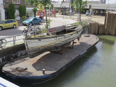 906367 Afbeelding van een platbodem met daarop een opgedregde roeiboot, aangemeerd bij de Oosterkade in de Vaartsche ...